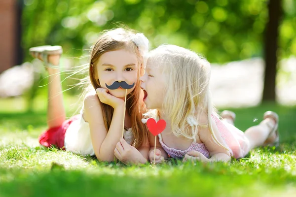 Girls playing with paper moustach — Stock Photo, Image