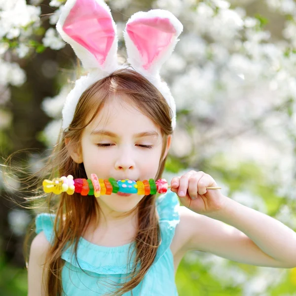 Menina comendo doces de goma coloridos — Fotografia de Stock