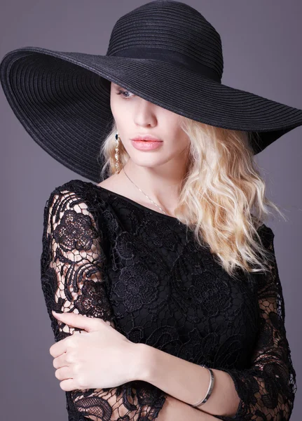 Jeune femme de luxe dans un grand chapeau noir  . — Photo