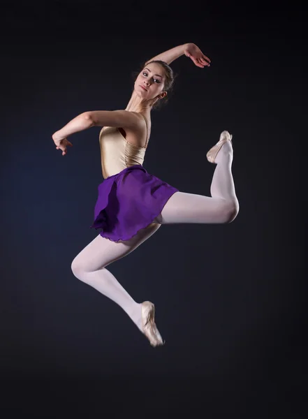 Salto ballerina su uno sfondo scuro . — Foto Stock