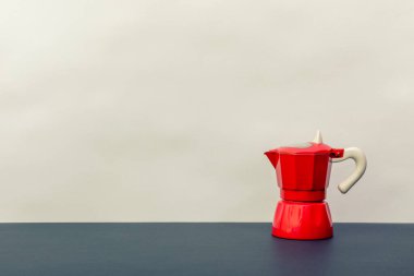 Masada kırmızı kahve demliği ve tasarım için yer var..