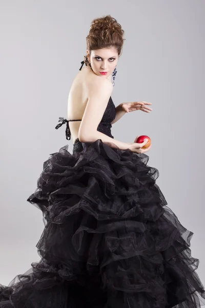 Женщина в черном платье с яблоком — стоковое фото