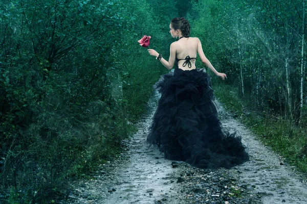 Mujer en vestido sosteniendo flor —  Fotos de Stock