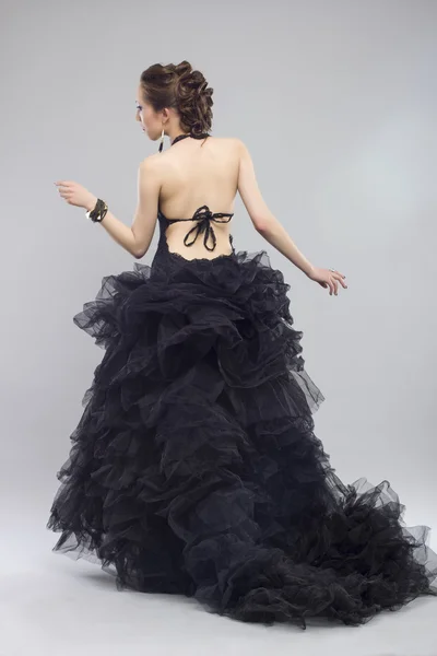 Женщина в роскошном длинном черном платье — стоковое фото