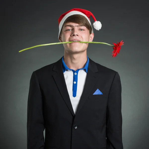 Homem com uma flor e boné de Papai Noel . — Fotografia de Stock