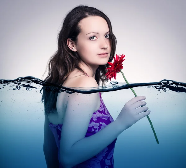 Meisje met een bloem in water. — Stockfoto