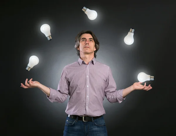 Mann jongliert mit Glühbirnen — Stockfoto