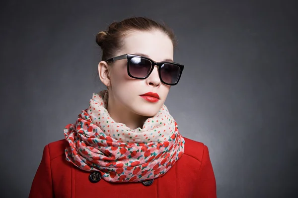 Mulher de casaco vermelho usando óculos de sol — Fotografia de Stock