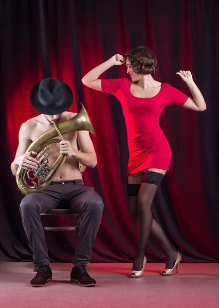 Mulher dançando e homem jogando tubo de latão . — Fotografia de Stock