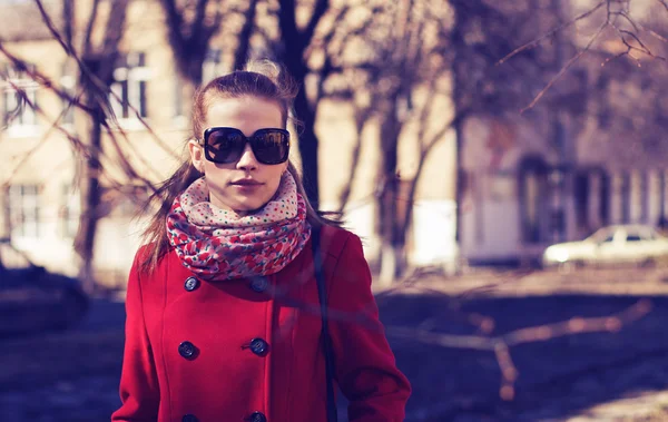 Vrouw in zonnebril en rode jas — Stockfoto