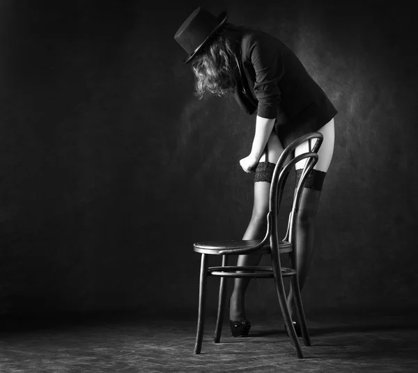 Sexy woman dancing around chair — Stock Photo, Image