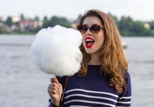 Menina comendo algodão doce — Fotografia de Stock