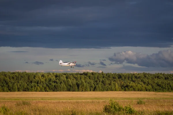 Aircraft flying over field — Stock Photo, Image