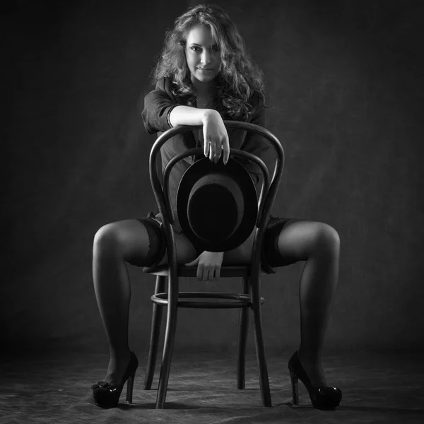 Sexy joven mujer sentada en silla —  Fotos de Stock