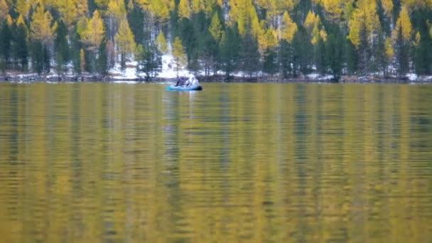 People rowing in a rubber boat on the water of a mountain lake Lower Multinskoe — Stock Footage People rowing in a rubber boat on the water of a mountain lake Lower Multinskoe Video Clip