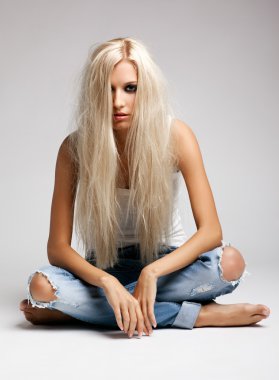 Blonde woman in ragged jeans and vest