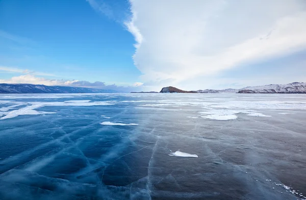 Winter ice landscape on lake Baikal with dramatic weather clouds