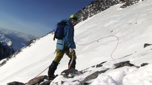 Альпинист собирается на вершину горы — стоковое видео