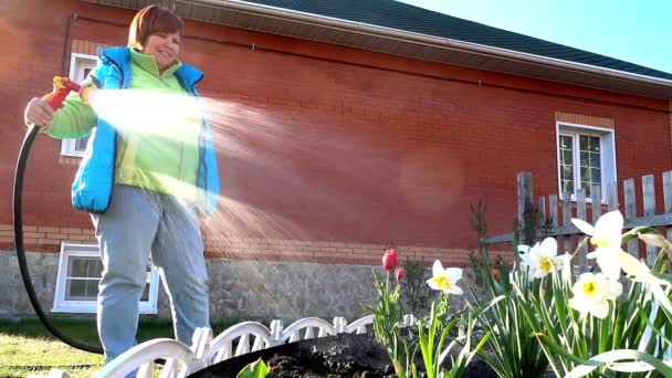 Frau gießt einen Garten — Stockvideo