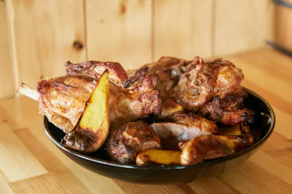 Gebratenes Fleisch Mit Kartoffeln Einem Schwarzen Teller Auf Einem Holztisch — Stockfoto