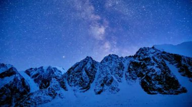 Geceleri dağların zirvelerinde güzel bir manzaranın yavaş çekim videosu