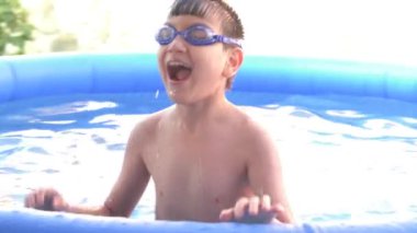 Küçük bir havuzda su sıçratan çocukların yavaş çekim videosu.