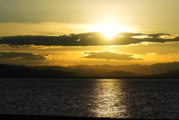 ウルグヌール湖の上に曇りの夕日 西モンゴルの生理食塩水湖 — ストック写真