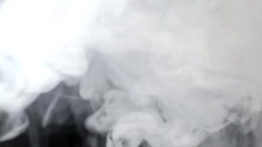 Karanlık arkaplanda yavaşça hareket eden dumanın görüntüleri