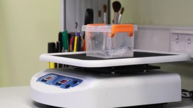 platform mixing chemicals with fabric sample in plastic container