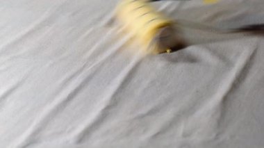 hand applying glue on wallpaper with paint roller