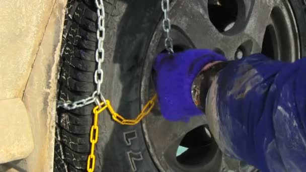 Man putting snow chains on tire — Stock Video