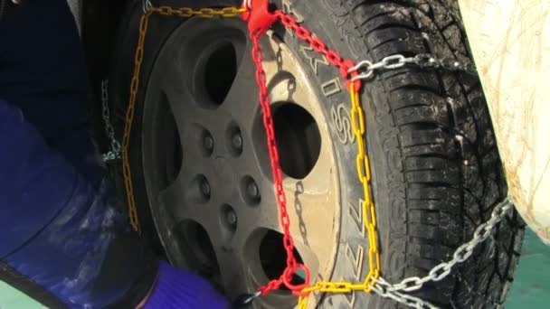 Man putting snow chains on tire — Stock Video