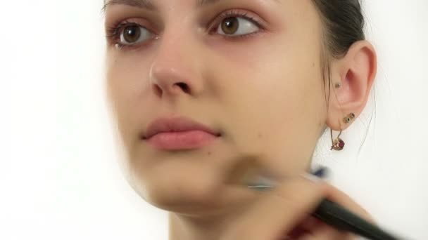 Нанесение макияжа красивой девушке — стоковое видео