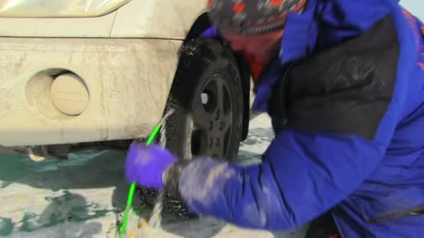 Homem colocando correntes de neve — Vídeo de Stock