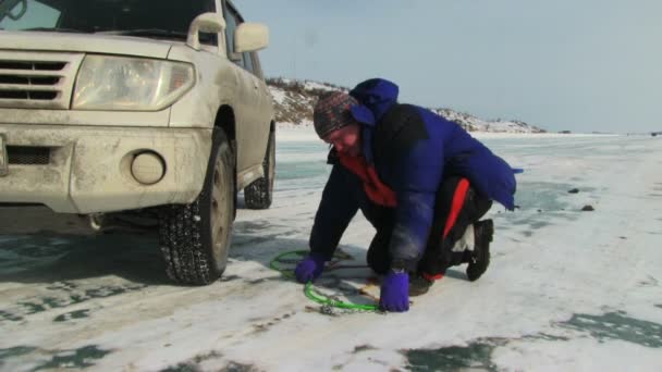 Man putting snow chains — Stock Video