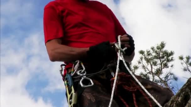 Rock climber adjusting harness — Stock Video