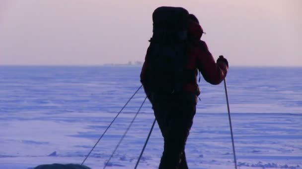 Homem vai ao pôr-do-sol no deserto de neve — Vídeo de Stock