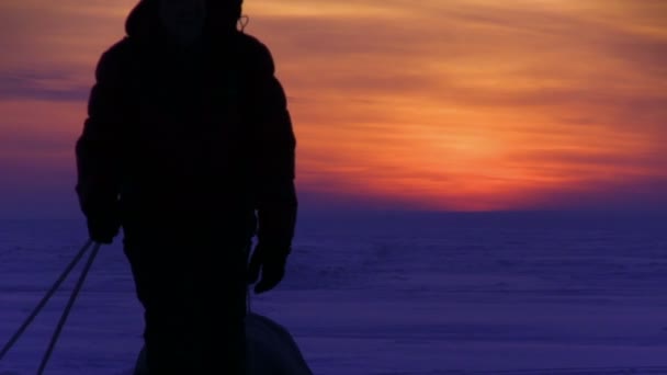 Homem vai ao pôr-do-sol no deserto de neve — Vídeo de Stock