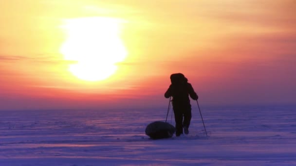 Man gaan tot zonsondergang op sneeuw woestijn — Stockvideo