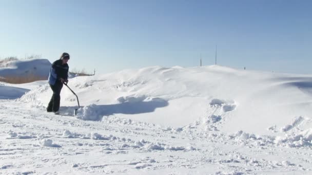Hombre paleando nieve del camino — Vídeo de stock