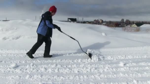 Человек убирает снег с дороги — стоковое видео