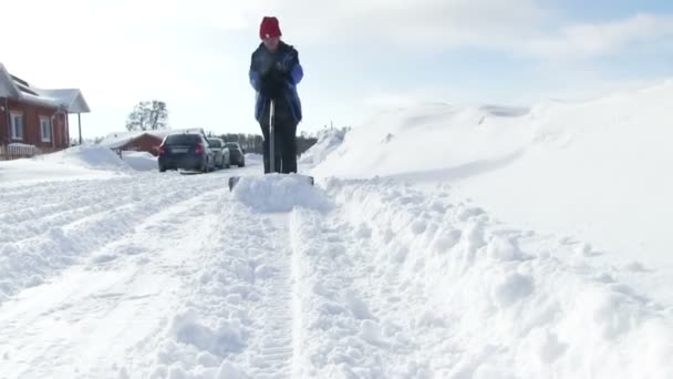 Mann schaufelt Schnee von der Straße — Stockvideo