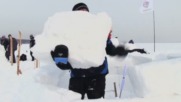 Homem constrói uma casa de neve - Igloo — Vídeo de Stock