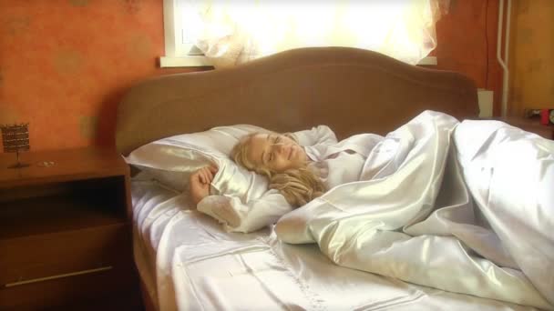 Kvinna som vaknar upp i sängen — Stockvideo