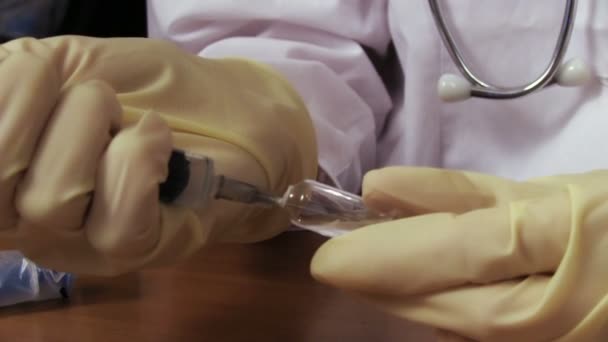 Доктор заполняет шприц лекарством — стоковое видео