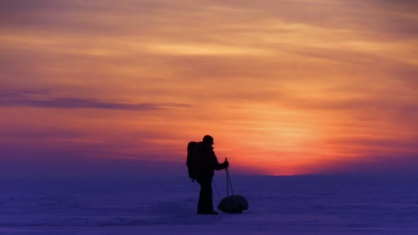 Homme dans le désert de neige au coucher du soleil 