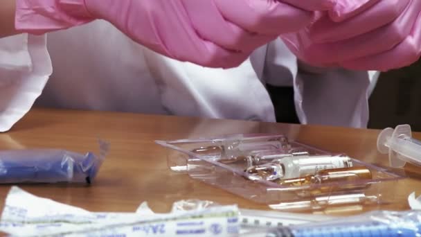 Doctor picks up vials and syringes — Stock Video
