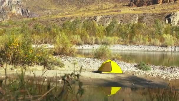 Желтая палатка на берегу осенней реки — стоковое видео