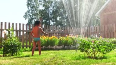 Küçük çocuk yağmurlama ile çalış