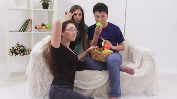 Трое молодых людей едят фрукты — стоковое видео